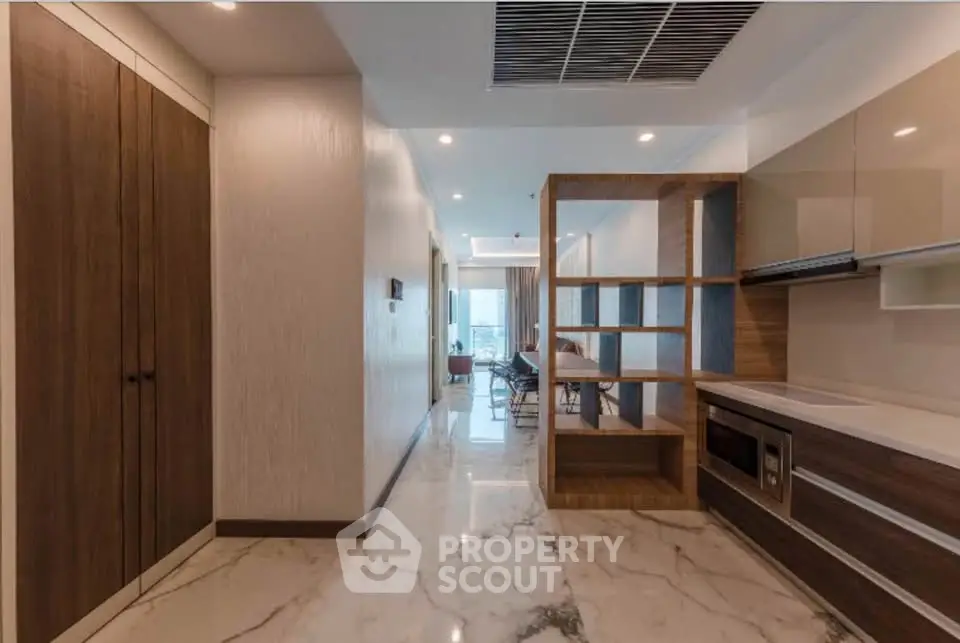 Luxurious modern apartment hallway with marble flooring and stylish wooden cabinetry.