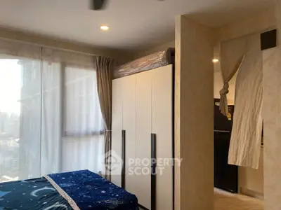 Cozy bedroom with large window and modern wardrobe in a stylish apartment.