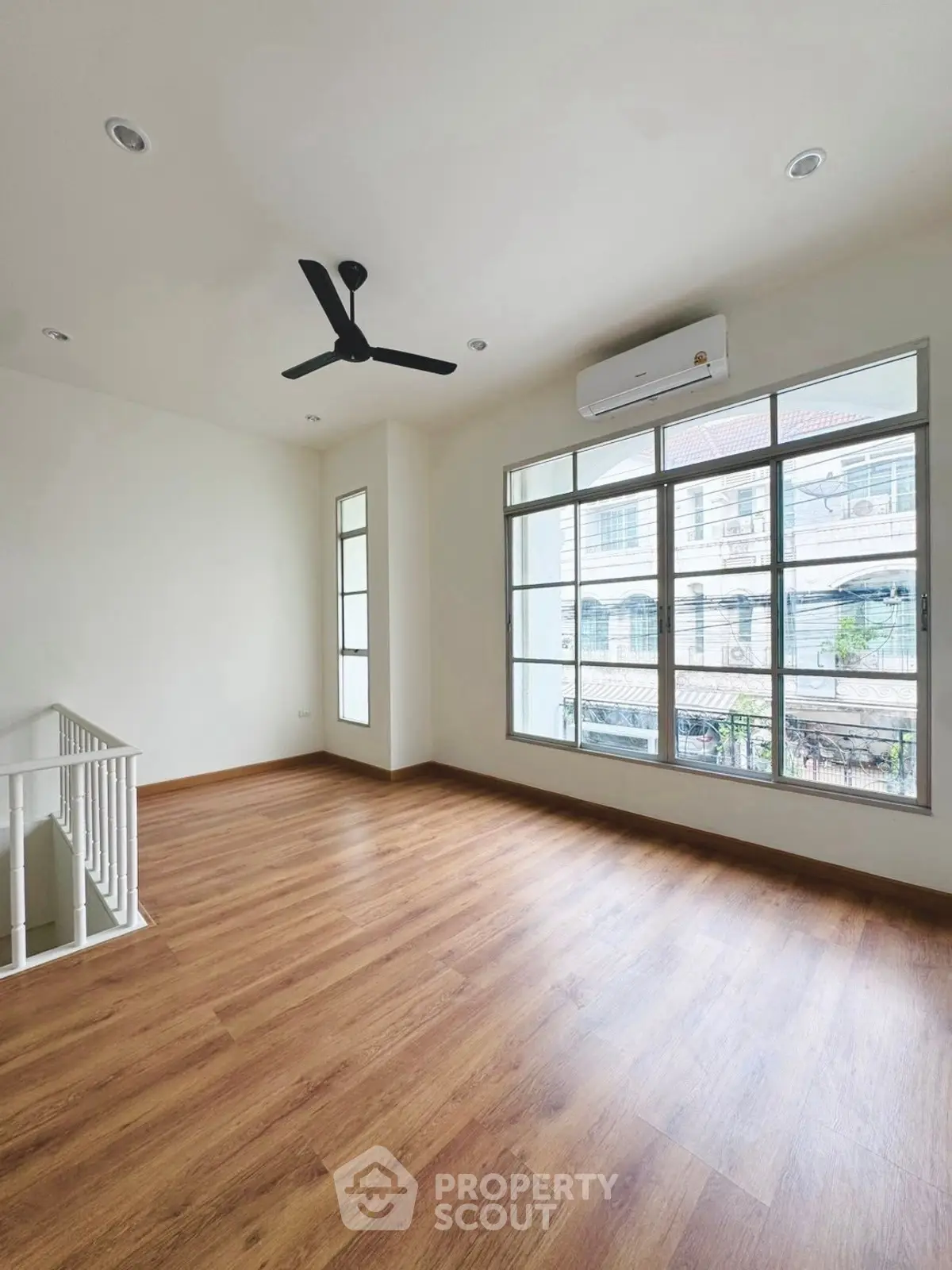 Spacious room with large windows and wooden flooring in modern home