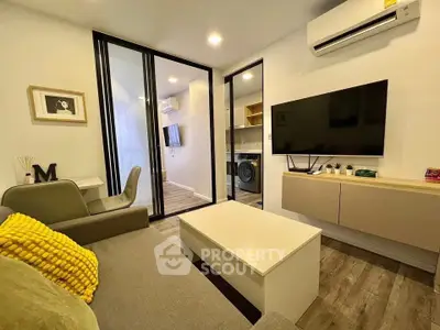 Modern living room with stylish decor and open layout, featuring a wall-mounted TV and air conditioning.