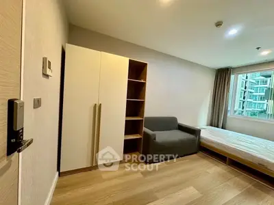 Modern bedroom with minimalist design, featuring a cozy bed, sleek wardrobe, and natural light from large window.