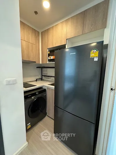 Modern compact kitchen with sleek appliances and wood cabinetry