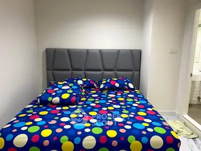 Cozy bedroom with colorful polka dot bedding and modern headboard