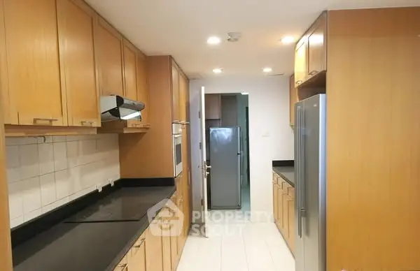 Spacious kitchen with ample wooden cabinetry and modern appliances