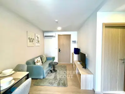 Modern living room with cozy sofa, TV, and dining area in stylish apartment.