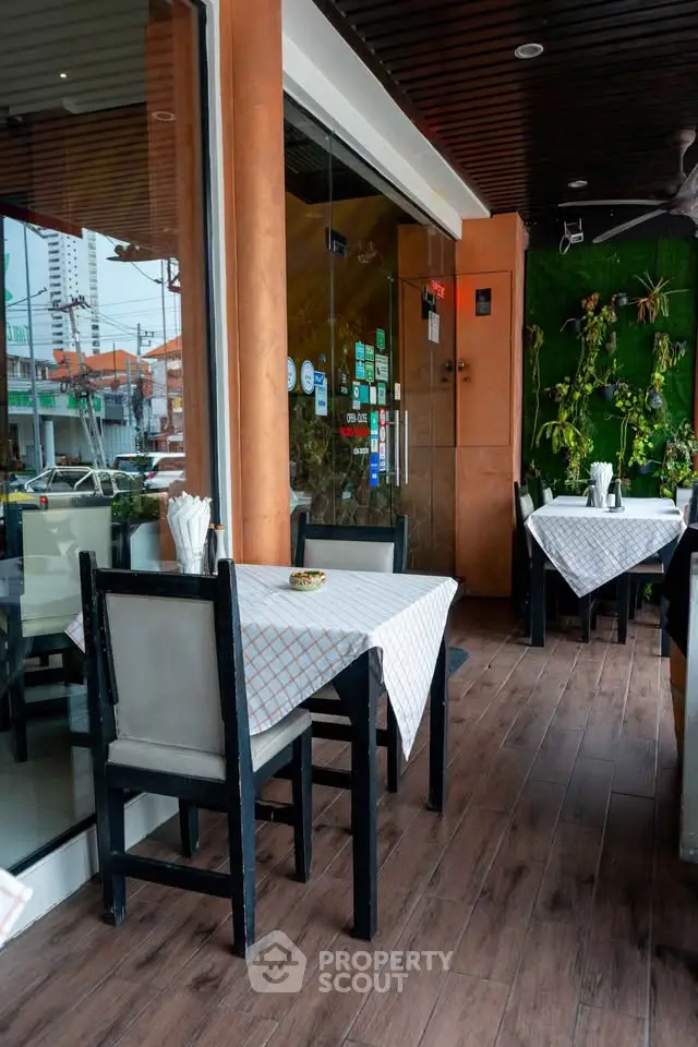 Charming outdoor dining area with modern decor and lush greenery, perfect for a cozy meal.