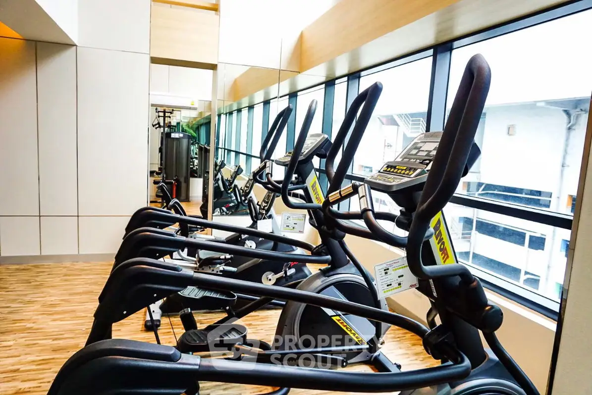 Modern gym with state-of-the-art exercise equipment and large windows for natural light.