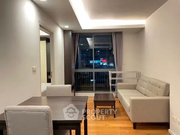 Modern living room with elegant furniture and city view through large windows.
