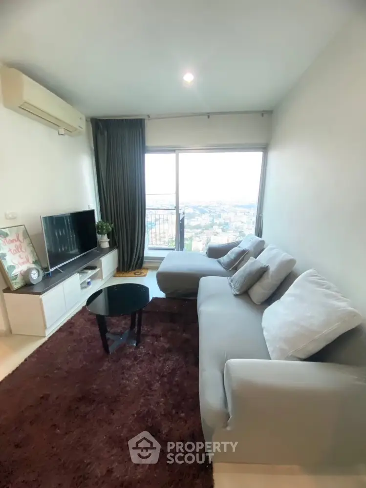 Modern living room with panoramic city view and cozy gray sofa