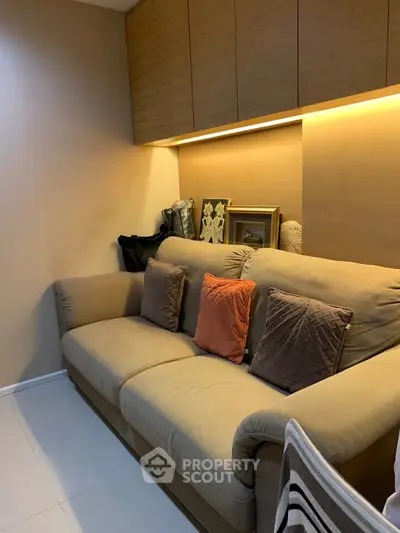 Cozy living room with plush sofa and ambient lighting, perfect for relaxation.