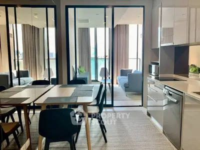 Modern open-plan kitchen and dining area with balcony view