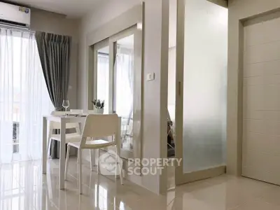 Modern dining area with glass doors and natural light in a stylish apartment.