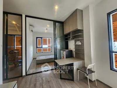 Modern study room with desk, shelves, and large windows in a stylish apartment.