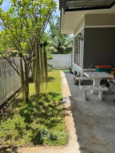 Charming backyard with lush greenery and cozy patio area perfect for relaxation and outdoor gatherings.
