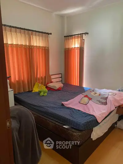 Cozy bedroom with natural light and comfortable bedding, perfect for relaxation.