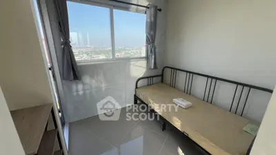 Cozy bedroom with single bed and stunning city view through large window.