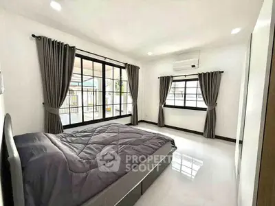 Spacious bedroom with large windows and modern decor