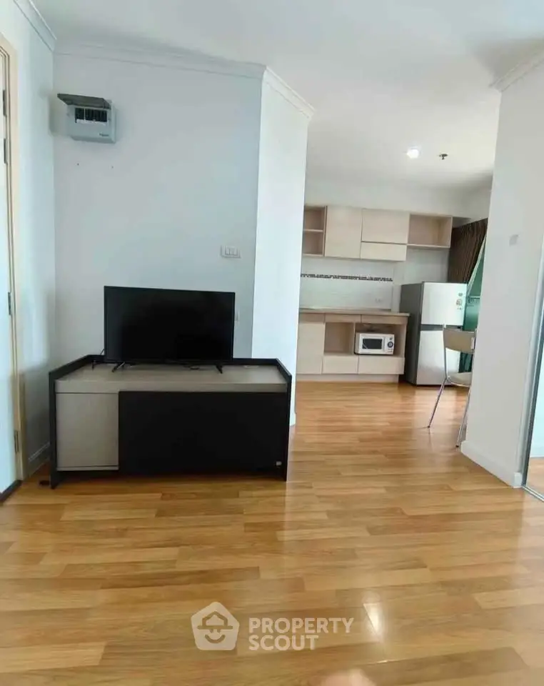 Modern living room with wooden flooring and open kitchen layout