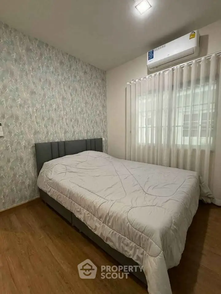 Cozy bedroom with modern decor and air conditioning, featuring a comfortable bed and stylish wallpaper.