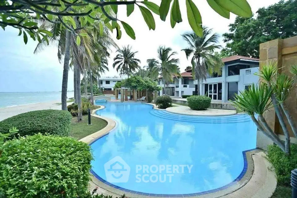 Luxurious beachfront property with stunning pool and lush tropical landscaping.