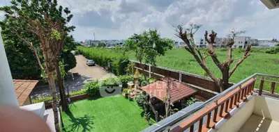 Spacious balcony with lush garden view in serene residential area