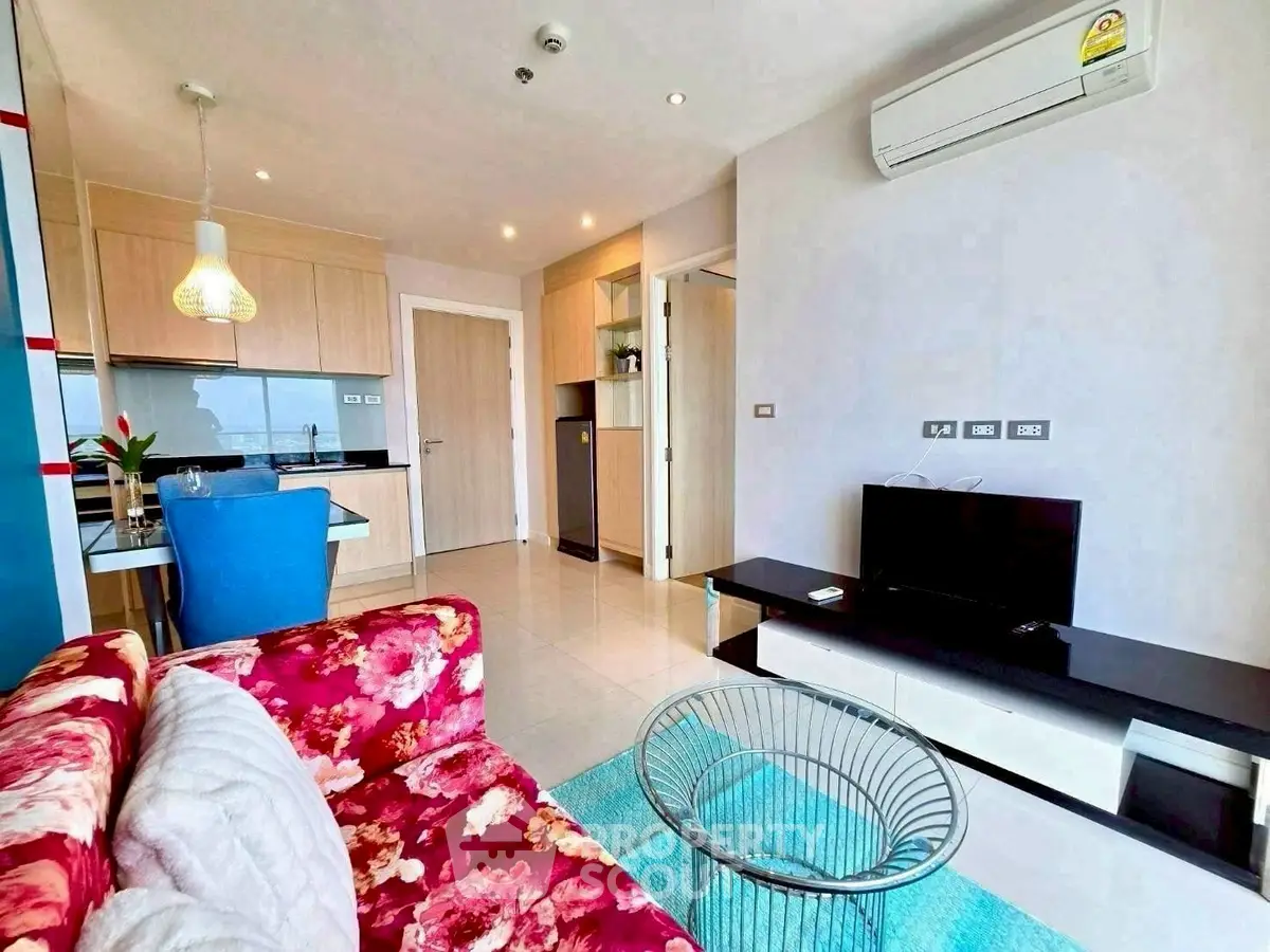 Modern living room with vibrant floral sofa and sleek kitchen area