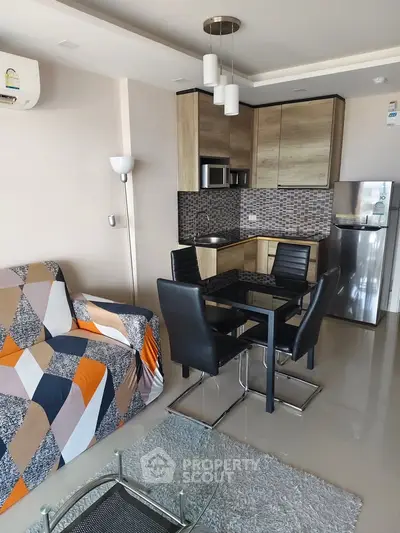 Modern living room with stylish kitchen, sleek furniture, and contemporary decor in a cozy apartment.
