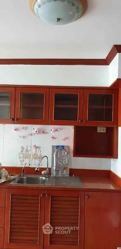 Charming kitchen with wooden cabinets and modern sink in a cozy apartment.