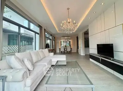 Luxurious living room with elegant chandelier and modern decor in a spacious open layout.