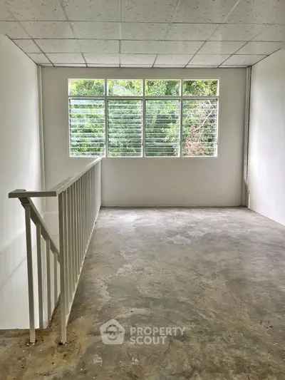 Spacious unfinished room with large windows and natural light