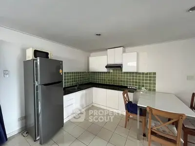 Modern kitchen with sleek appliances and stylish green tile backsplash, perfect for culinary enthusiasts.
