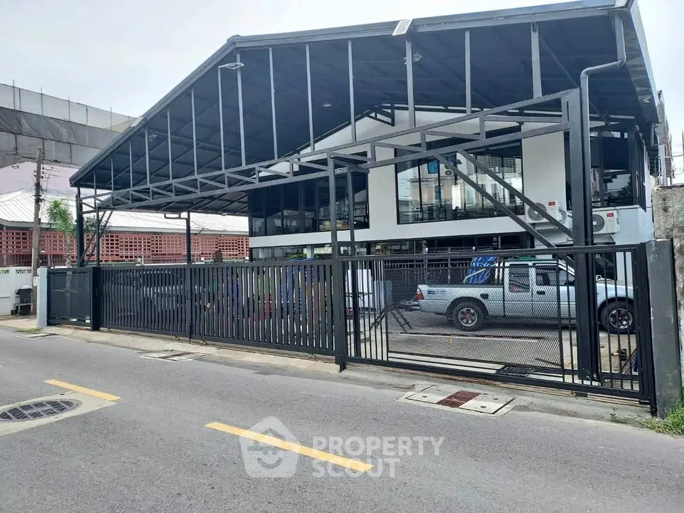 Modern industrial-style building with sleek metal framework and glass facade, ideal for commercial use.