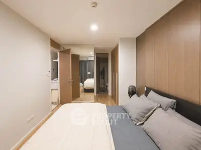 Modern bedroom with wooden accents and cozy bedding in a stylish apartment.