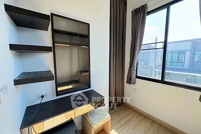 Modern study room with sleek desk and shelves, large window with natural light.