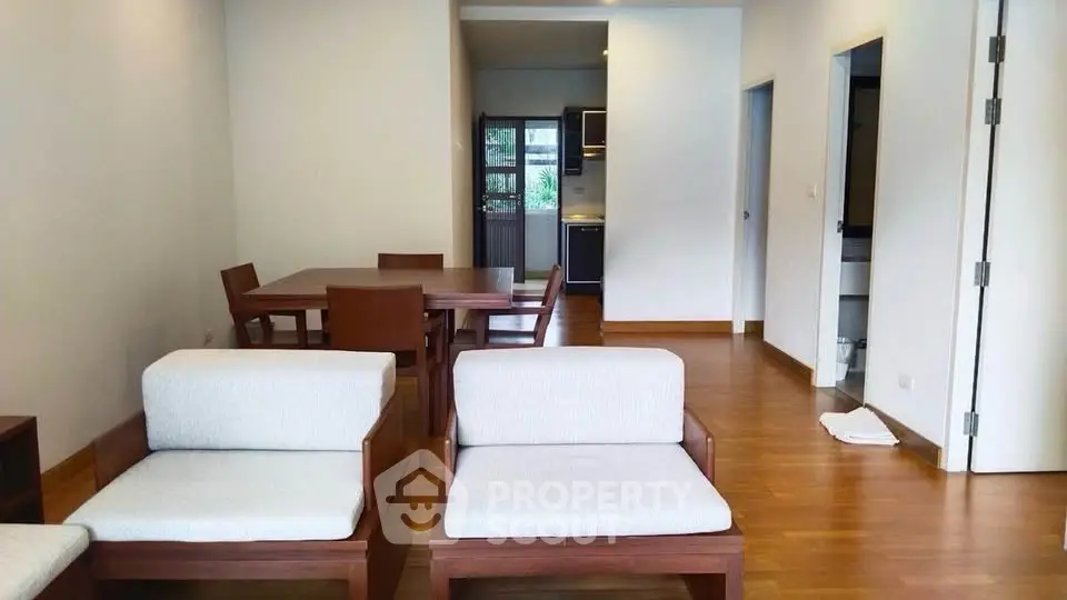 Spacious living room with wooden flooring and modern furniture in a cozy apartment.