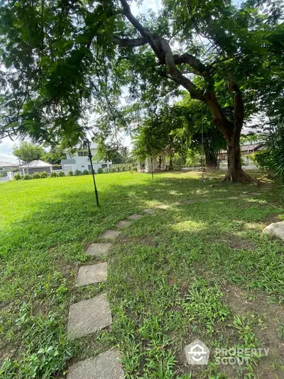 Spacious garden with lush greenery and mature trees in a serene residential area.