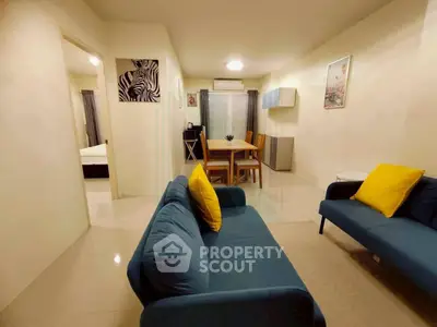 Spacious living room with modern decor and vibrant accents in a cozy apartment.