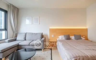 Modern studio apartment with cozy bed and stylish sofa in bright living space.