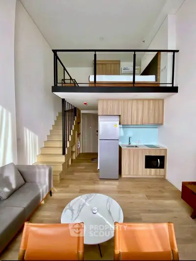 Modern loft apartment with mezzanine bedroom, stylish living area, and compact kitchen.