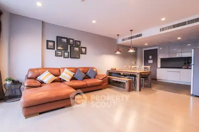 Spacious modern living room with leather sofa and open kitchen layout