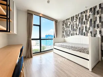 Bright and modern bedroom with stylish decor and large window view.