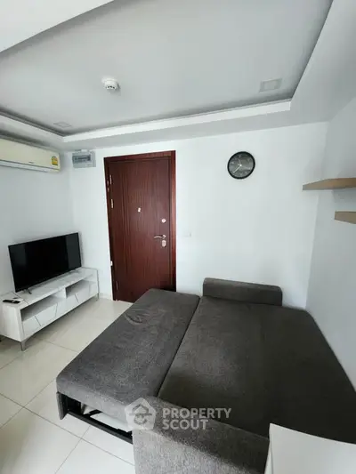 Modern living room with sleek sofa bed and wall-mounted TV in minimalist design.