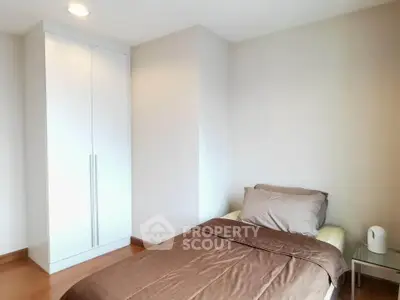 Cozy bedroom with single bed and built-in wardrobe in modern apartment
