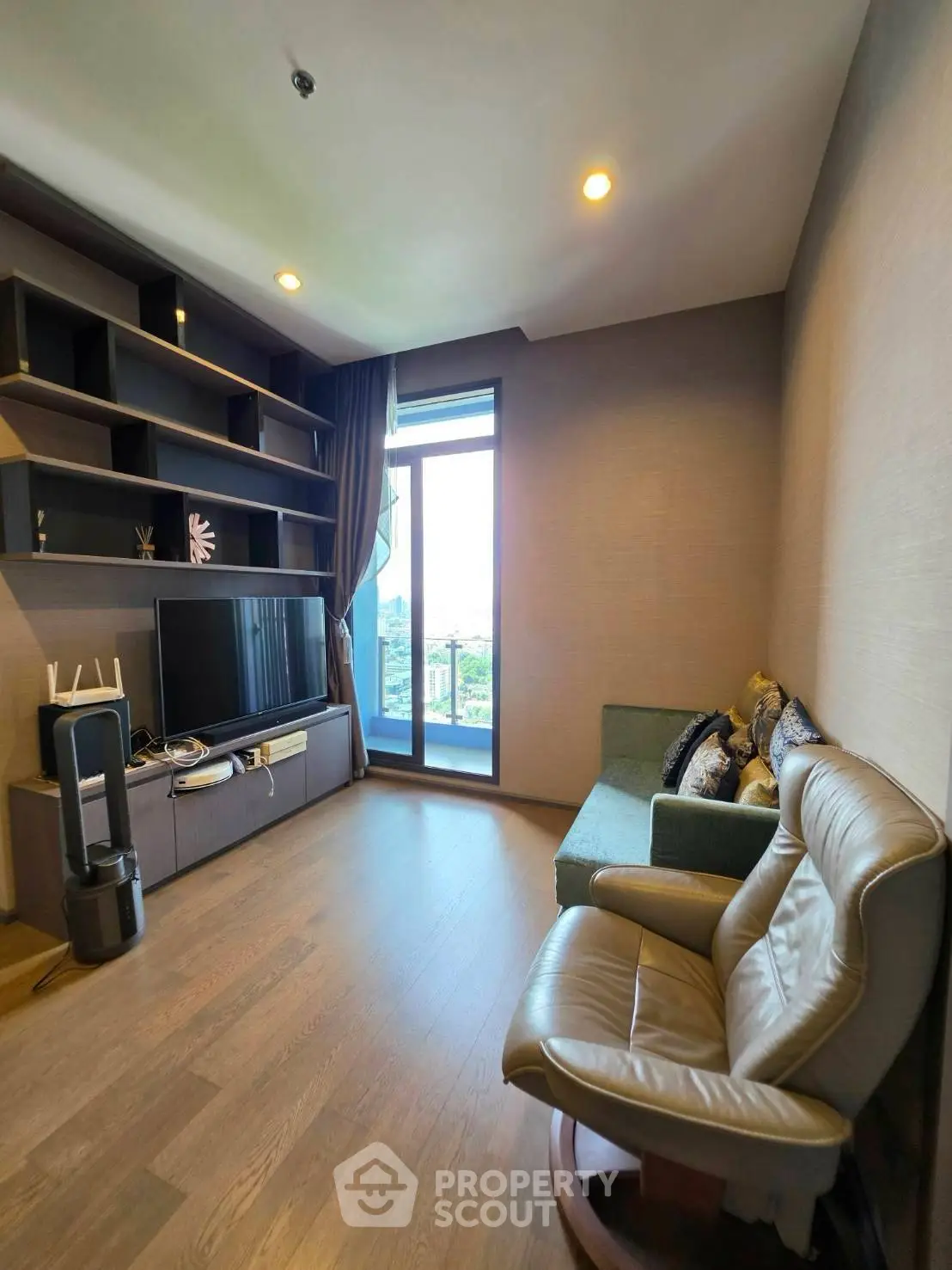 Modern living room with sleek furniture and large window offering city view