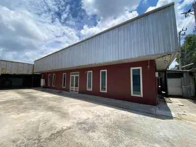 Spacious commercial building with ample parking and modern design under a clear blue sky.