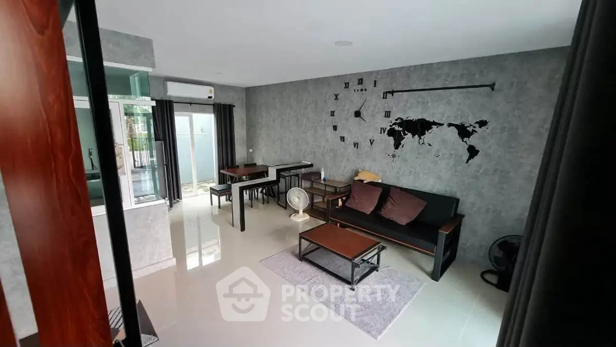 Modern living room with stylish decor and wall clock, featuring sleek furniture and natural light.
