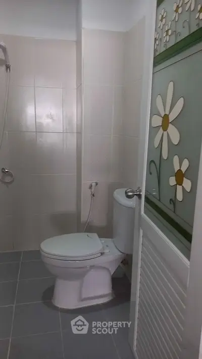 Modern bathroom with floral door design and sleek fixtures.