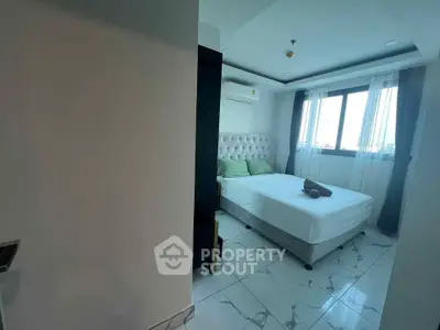 Modern bedroom with elegant decor and large window offering natural light