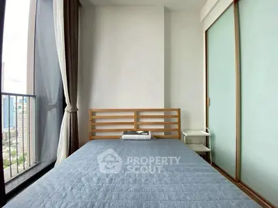 Modern bedroom with large window and city view, featuring minimalist design and sliding closet doors.