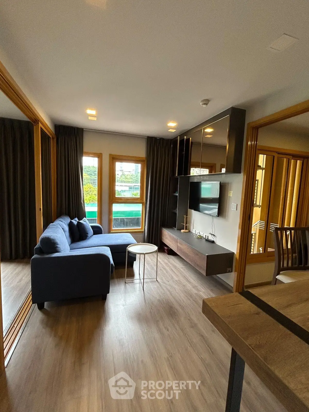 Modern living room with stylish furniture and large windows offering natural light.